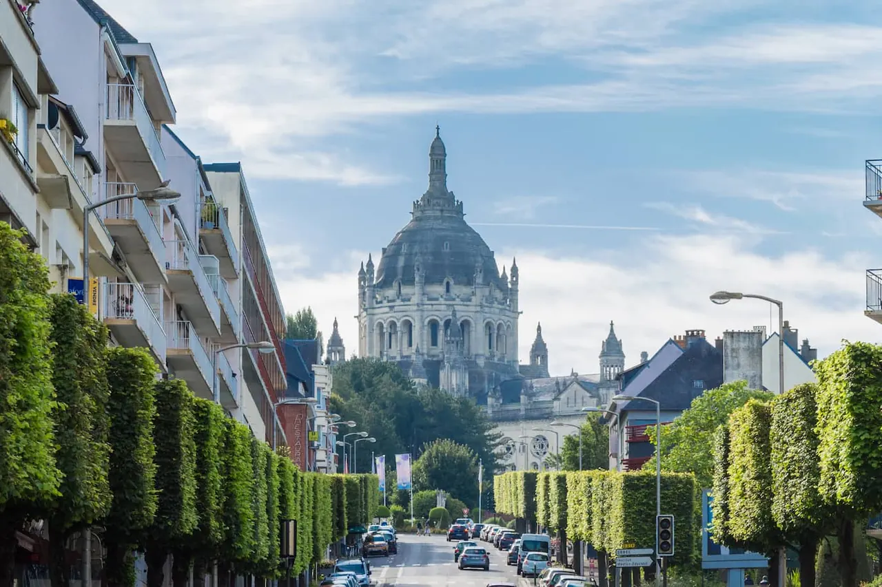 Avenue bordée d’arbres taillés montant vers la basilique Sainte-Thérèse de Lisieux